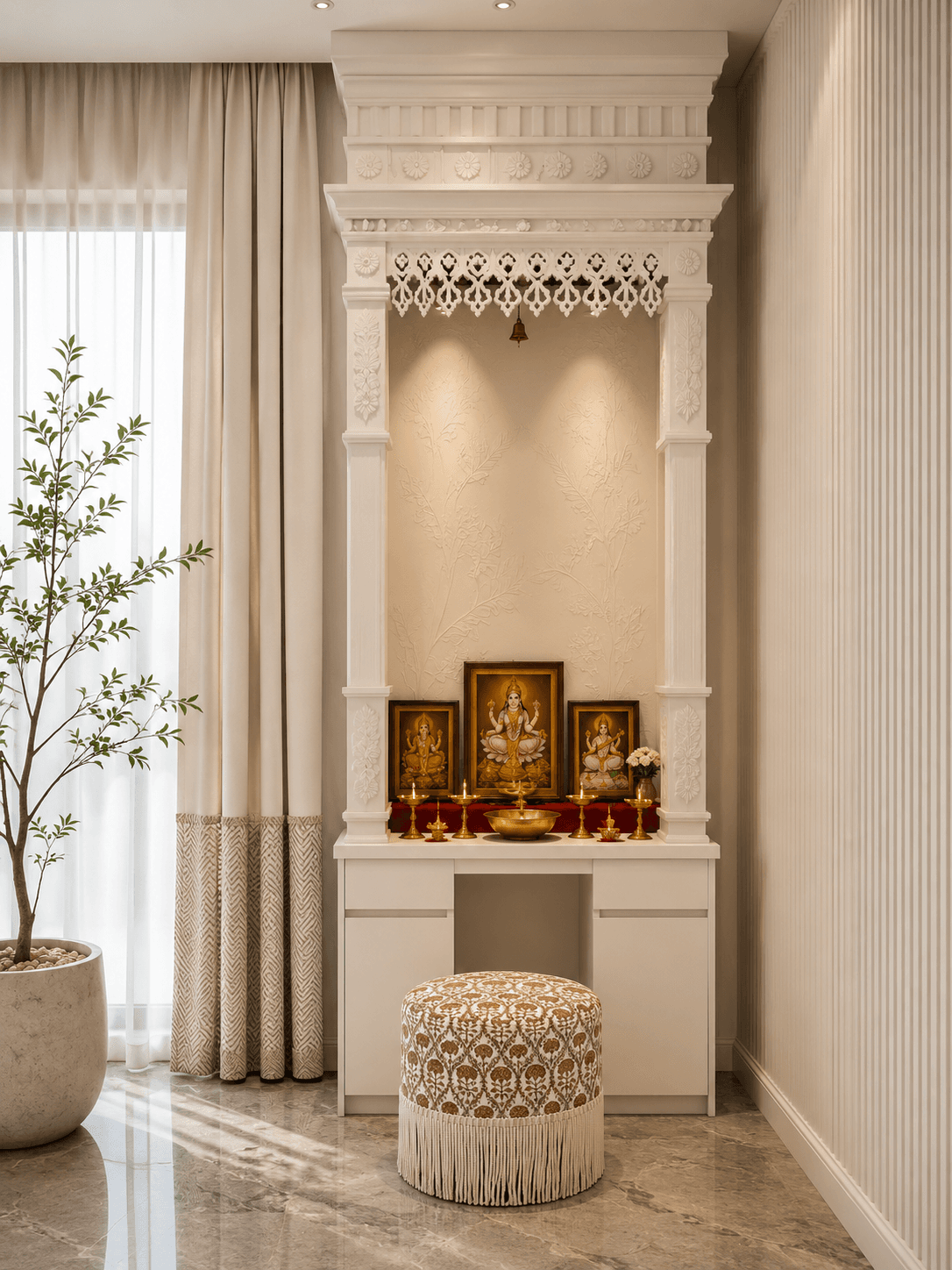 Floor-to-ceiling white carved puja mandir with brass diyas, framed deities, and a fringed floral ottoman